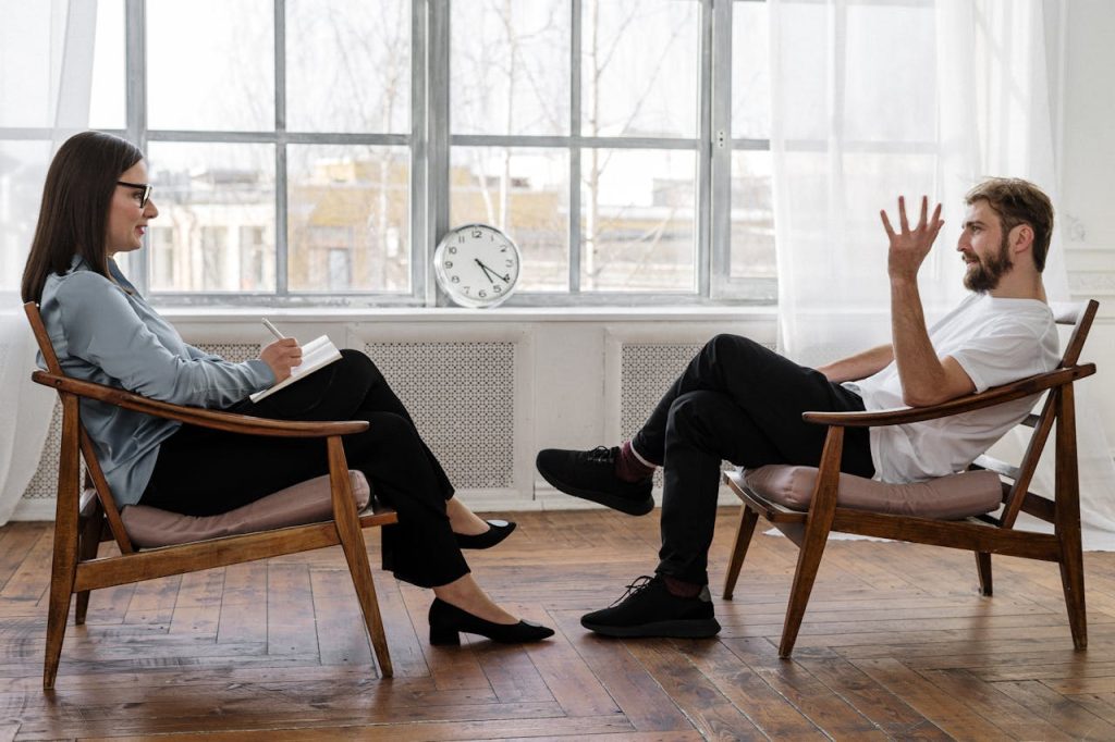 pexels-photo-4101143 Person in Black Pants and Black Shoes Sitting on Brown Wooden Chair